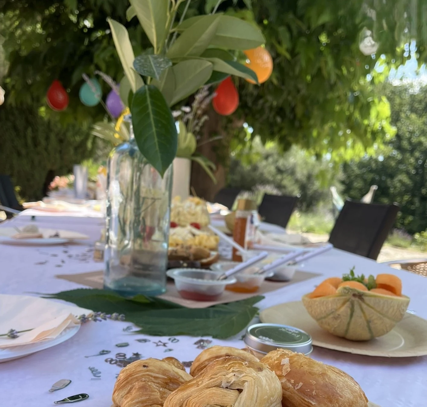 Grande tablée dressée sous les arbres pour une réception privée